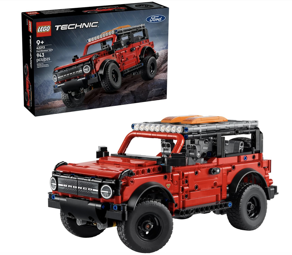 LEGO Technic Ford Bronco SUV vehicle with lots of details that reflect the real thing such as the roof rack and spare tire. The Bronco model is set in front of the box it is packaged in with a picture of the Ford Bronco driving off road in the pouring rain. 