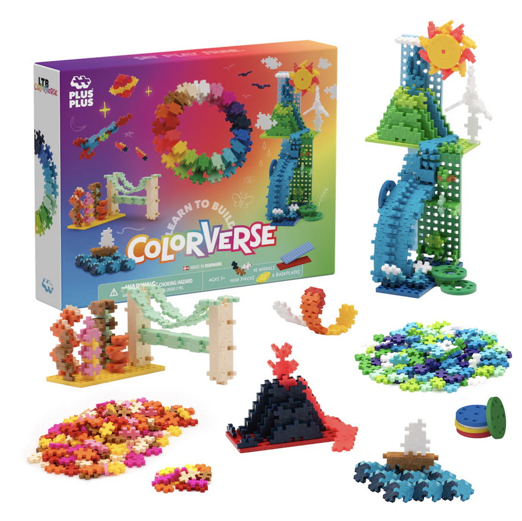 Piles of Plus Plus pieces in pink, yellow, white and brown, blue, green, purple and chartreuse among various builds such as a sail boat, and a volcano dripping lava all set in front of the colorful box that the Plus Plus Colorverse building set is packaged in. 
