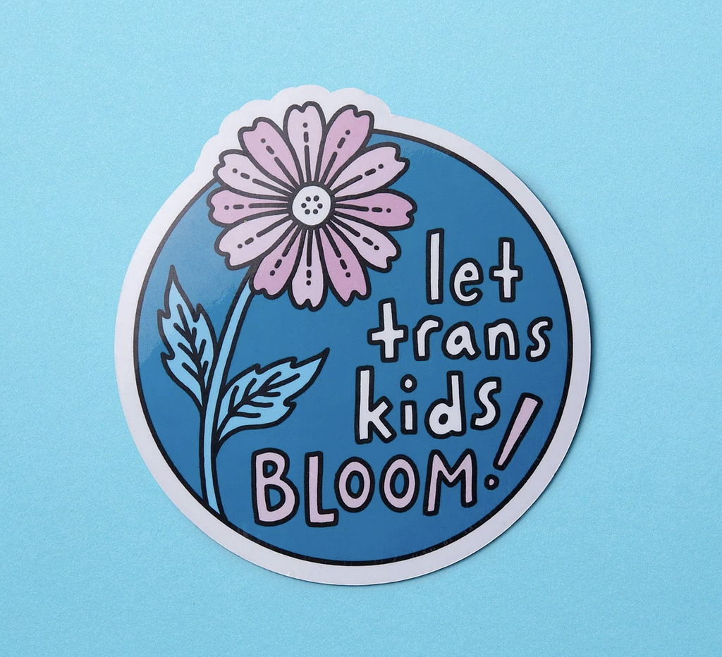 Round magnet with blue background and white lettering with a purple flower that reads "Let Trans Kids Bloom!"