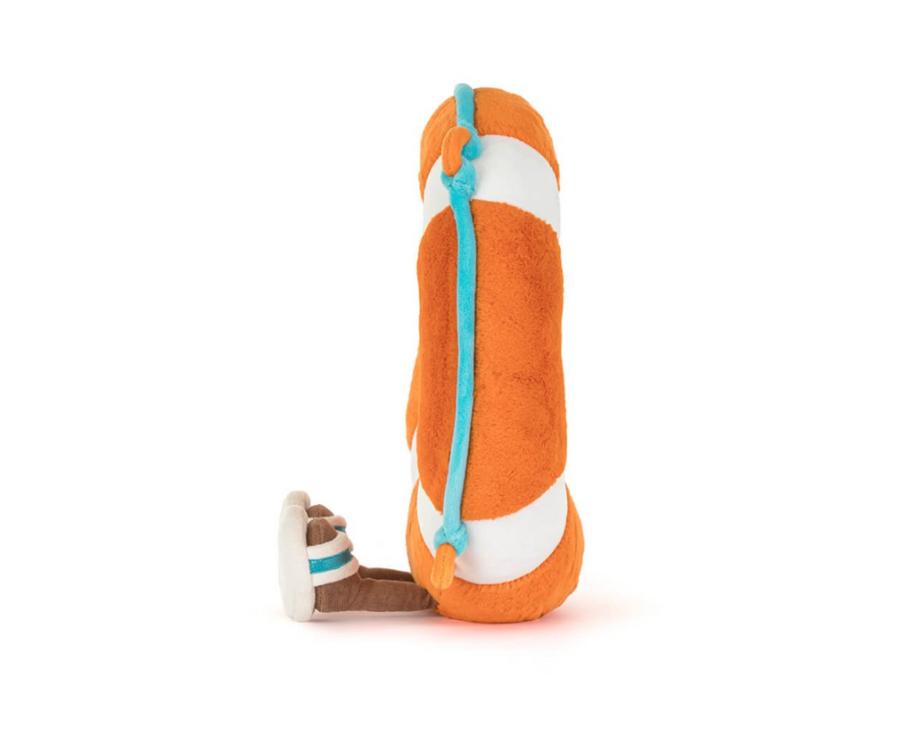 Side view of an orange and white striped plush life saver with brown legs wearing flip flops sitting on a white background.