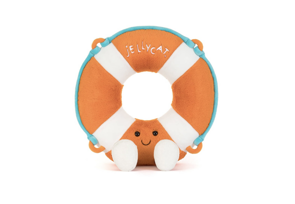 Orange and white plush life saver with a smiling face sitting on a white background.