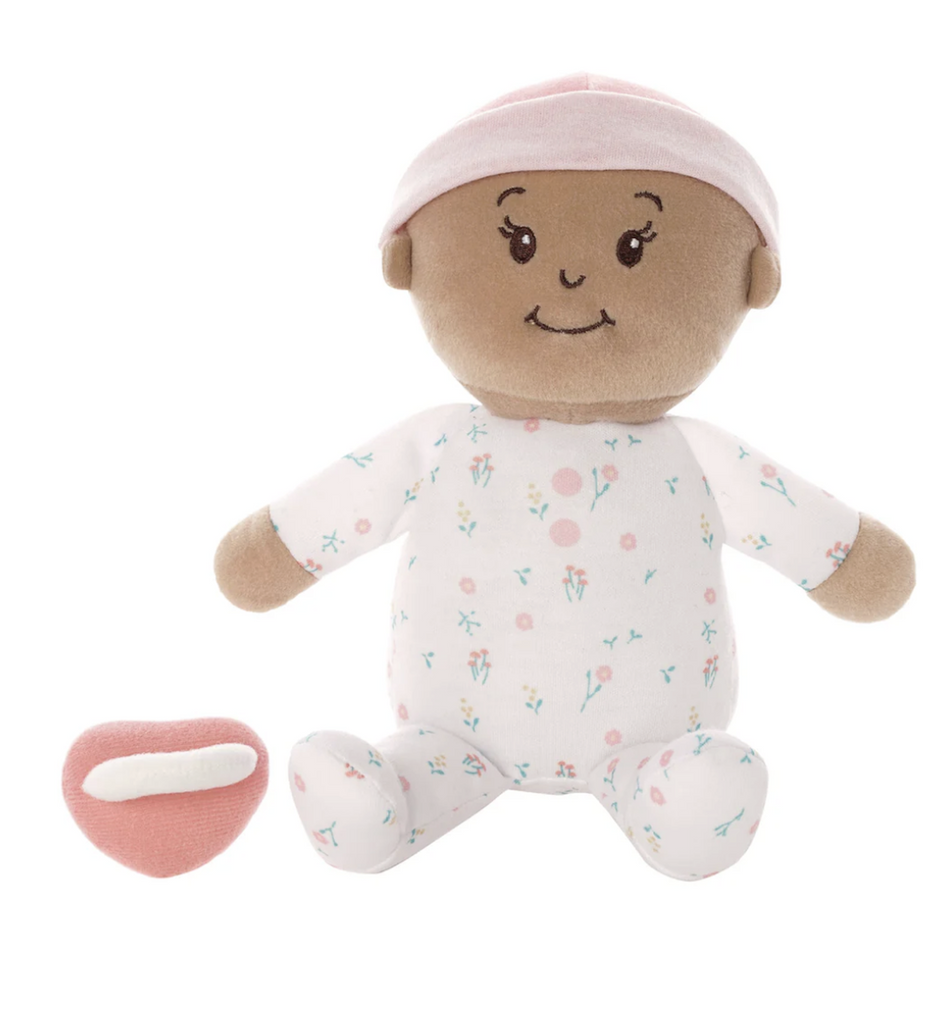 Plush Love, Stella baby doll with beige skin tone in a seated position wearing pink floral pajamas and hat. 