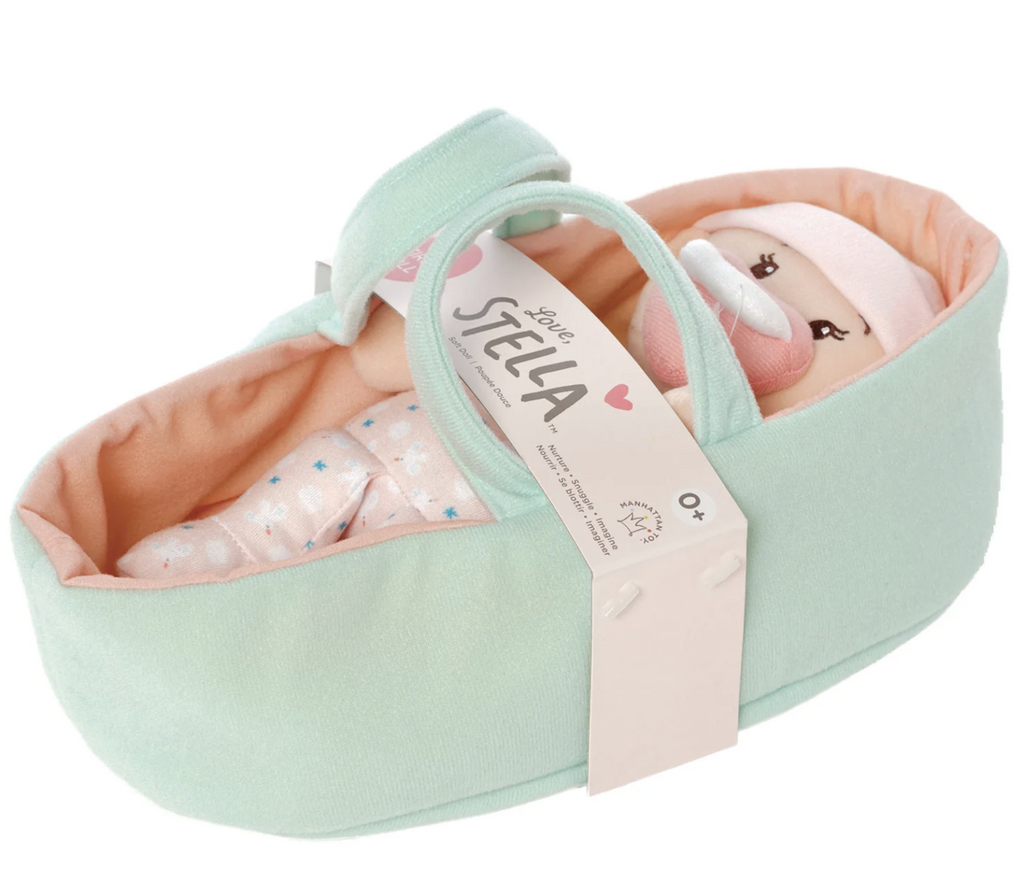 Love, Stella Peach baby doll laying in a plush bassinet with handles. 