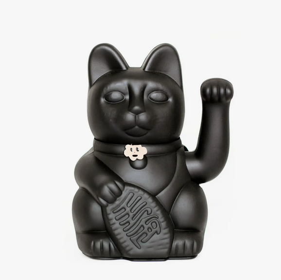 Black Lucky Cat statue with a waving arm and holding a banner that translates to "Good Luck" 