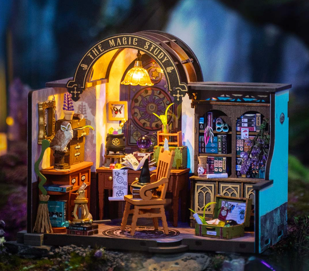 The Magic Study DIY Miniature House completely built and lit up in a dark room . 