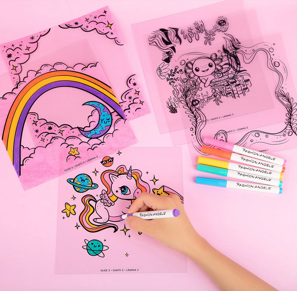 Coloring sheets with unicorn, rainbow, and space-themed designs from the Make A Scene DIY Shadow Box, the unicorn is being colored in with the included acrylic markers. 