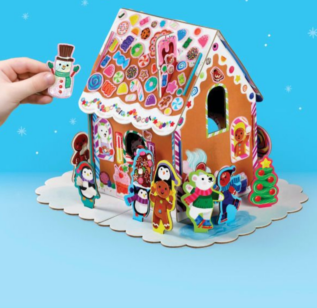 Colorful gingerbread house with stickers decorating the roof and all around are holiday characters. 