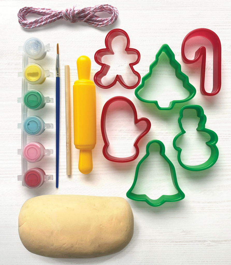 All the items included in the Make & Paint Clay Cookie Ornaments kit. Dough, rolling pin, paints, cookie cutters and twine. 