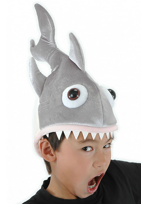 Maneater Shark Plush Hat. This cotton and polyester hat is shaped like a shark, complete with dorsal and side fins, a curved tail and plastic eyes. Foam teeth surround the head opening, which is designed to look like the shark's mouth. Shown here being worn by a child. 