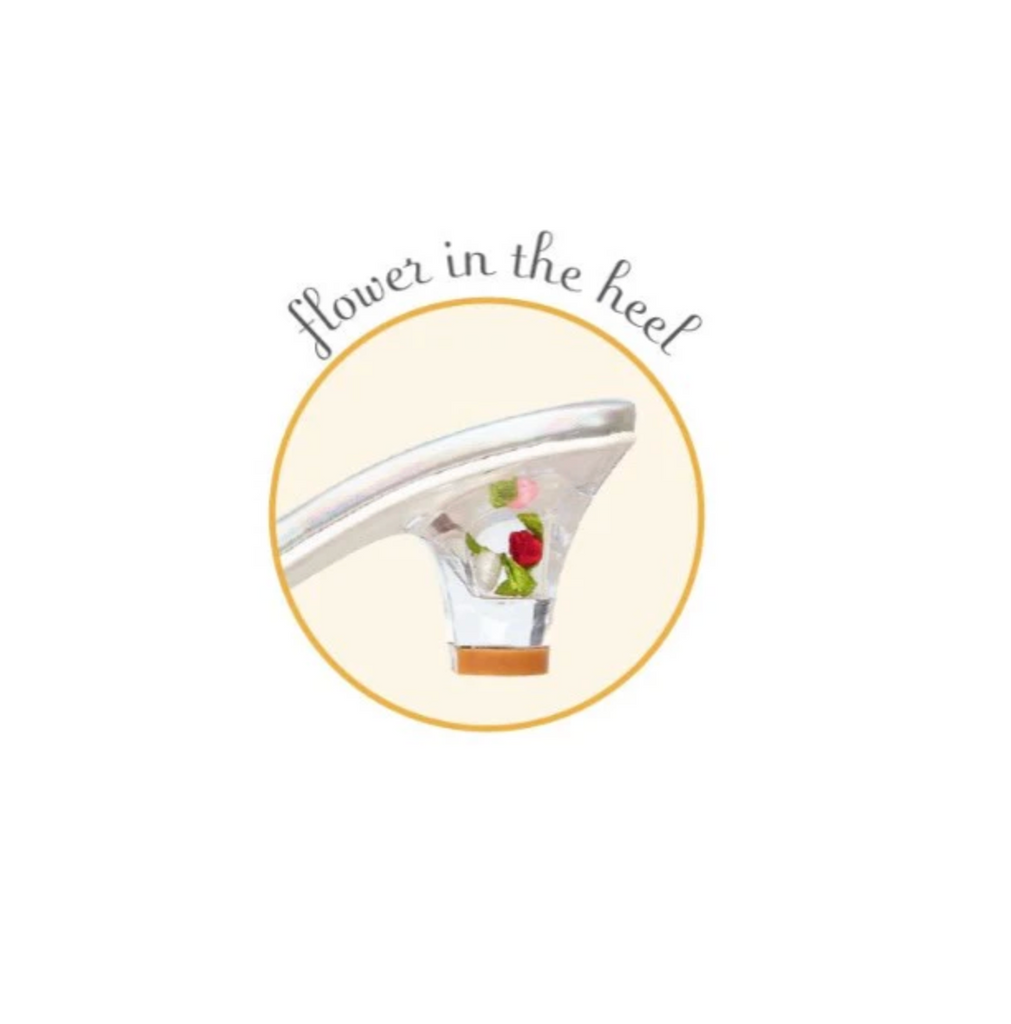 Close-up of a shoe with a flower detail inside the clear heel of the dress up slippers. 