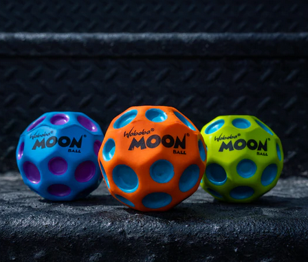Trio of super high bouncy balls with craters. Assorted colors include bright blue with purple dots, orange with blue dots and greenish, yellow with blue dots. 