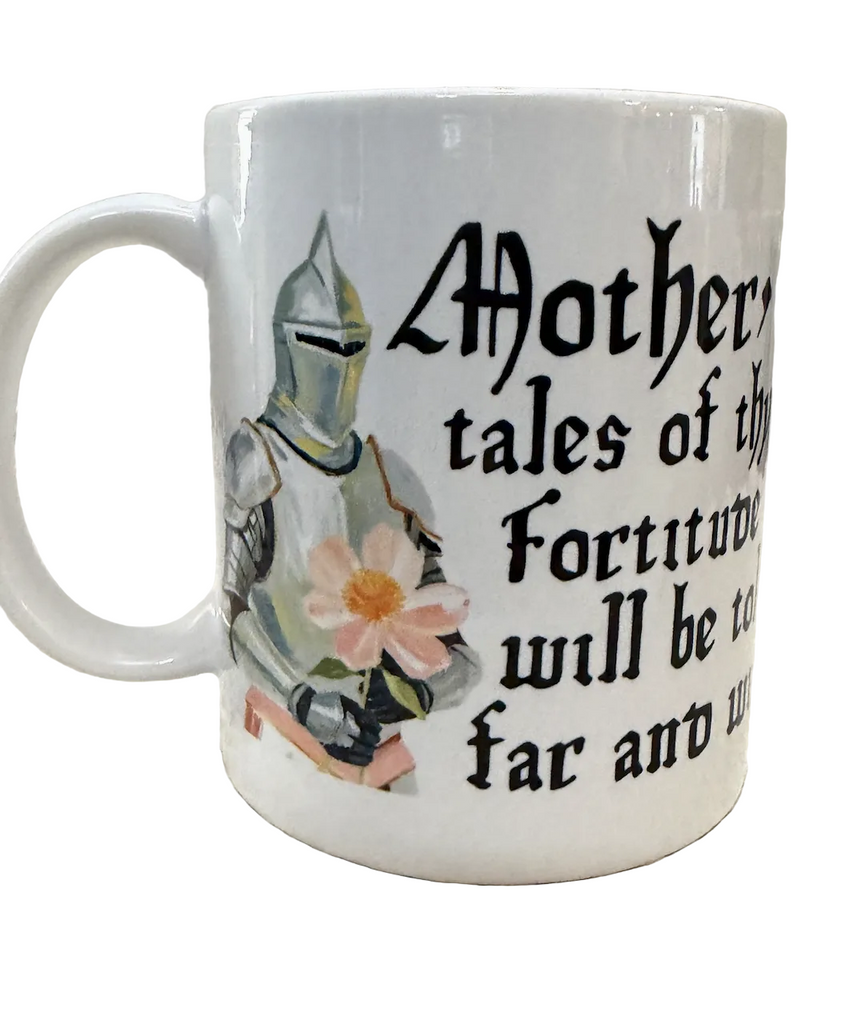 White ceramic mug featuring a medieval knight in armor holding a flower with black lettering that reads "Mother, tales of thy fortitude will be told far and wide" 