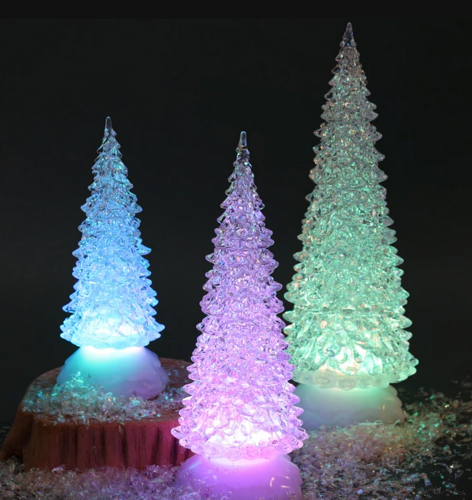 Three colorful LED Christmas trees on a dark background. The medium size is pictured in the middle and is lit up purple. 