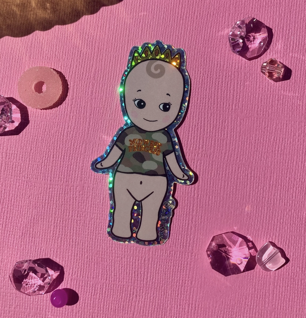 Midwest Princess Kewpie glitter sticker on a bright pink background. 