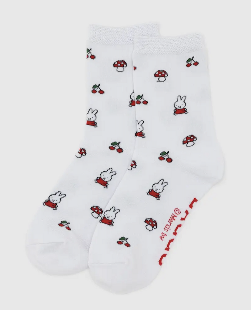 WHite crew socks with a pattern of Miffy bunny wearing a red dress, mushrooms and cherries all over them. 