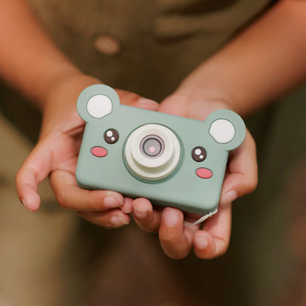 Kids hands holding the Mikayo the Bear Digital Camera. 