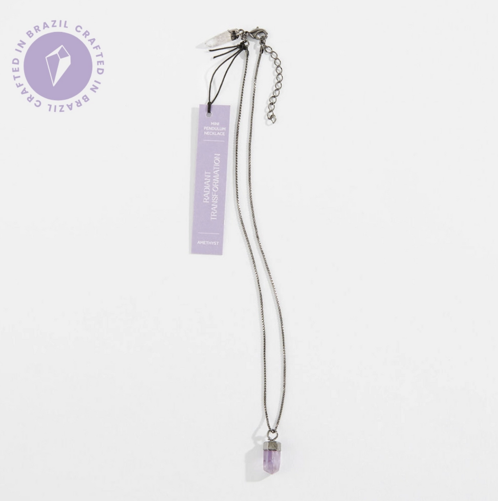 The Mini Amethyst Crystal Pendulum Necklace on a box chain that has a tiny quartz pendulum at the back clasp of the necklace along with an extender. 