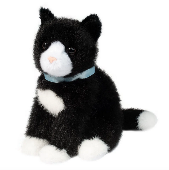 The Mini Black and White Cat sitting up and facing forward with black fur with elegant white markings on her face, chest, paws, and the tip of her tail. A small, pink nose and a baby blue satin collar. 