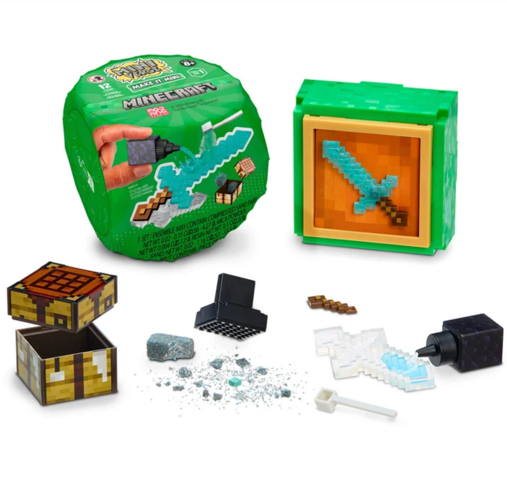 The green Minecraft Miniverse cube in the background with all the compnenets of the craft as well as the finished collectible that was made. 