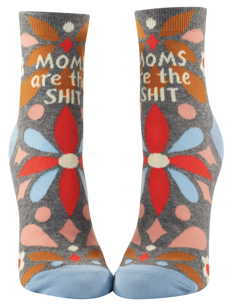 Pair of socks on mannequin feet with grey background and geometric floral pattern that read "Moms Are the Shit"