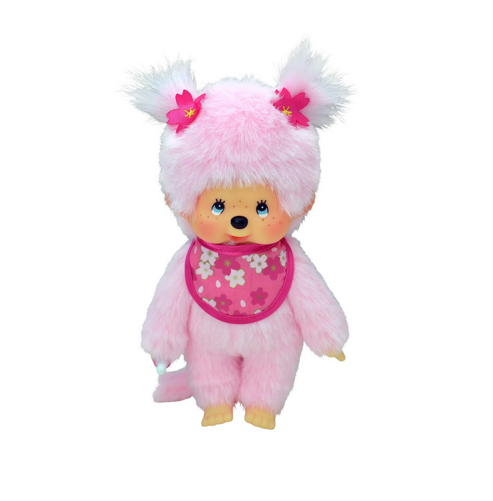 Monchhichi Bebichhichi plush doll wearing a pink bib with cherry blossoms and cherry blossom bows on her pigtails. 