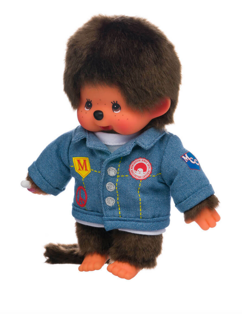 The Monchichi plush doll wearing a denim jacket with patches. 