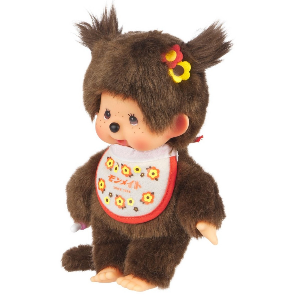 Retro Monmate Monchhchi plush doll in a standing position viewed from the left side so you could see the yellow and red flowers in her hair. 