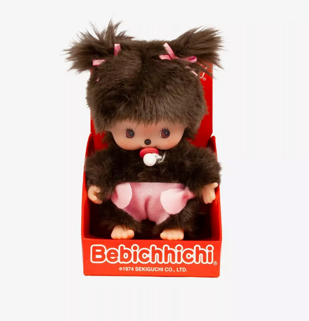 Sweet little Bebichhichi Monchhichi Girl wearing a pink diaper with two pink ribbons in her hair and a pacifier. 