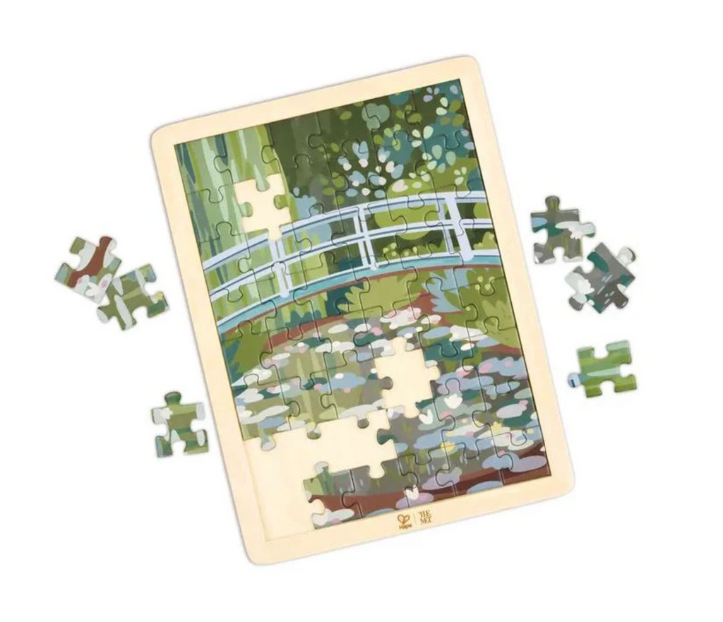 The Monet Water Lily Garden puzzle ion progress surrounded with a wooden frame. 