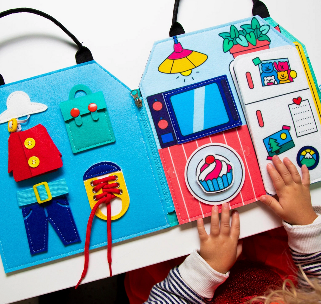 The Montessori Play Kit opened to a page with activities to familiarize children with everyday actions. With basic concepts and actions like shoelaces, and daily routines in the kitchen. 