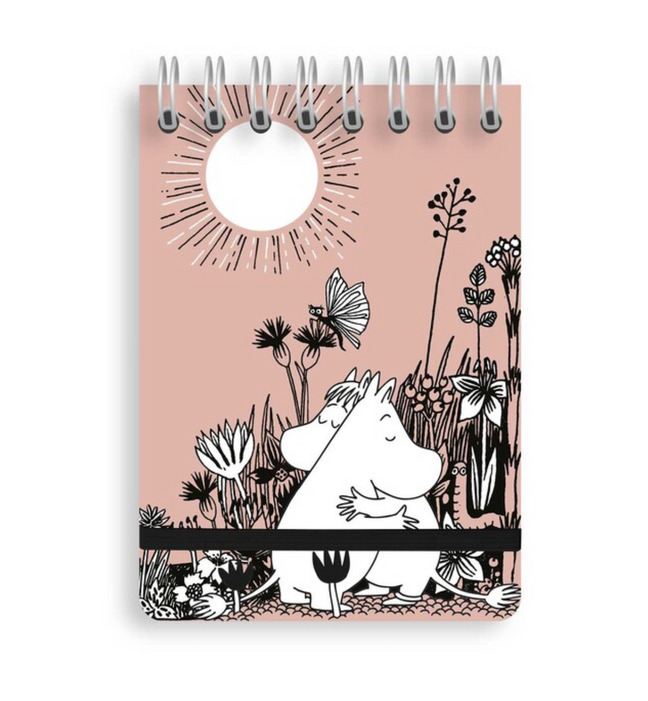Dusty pink cover of a spiral pocket notebook with an illustration of Moomin amongst flowers. 