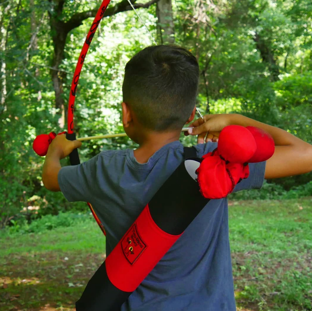 A child using the Two Bros. Bows set aiming at a target. 