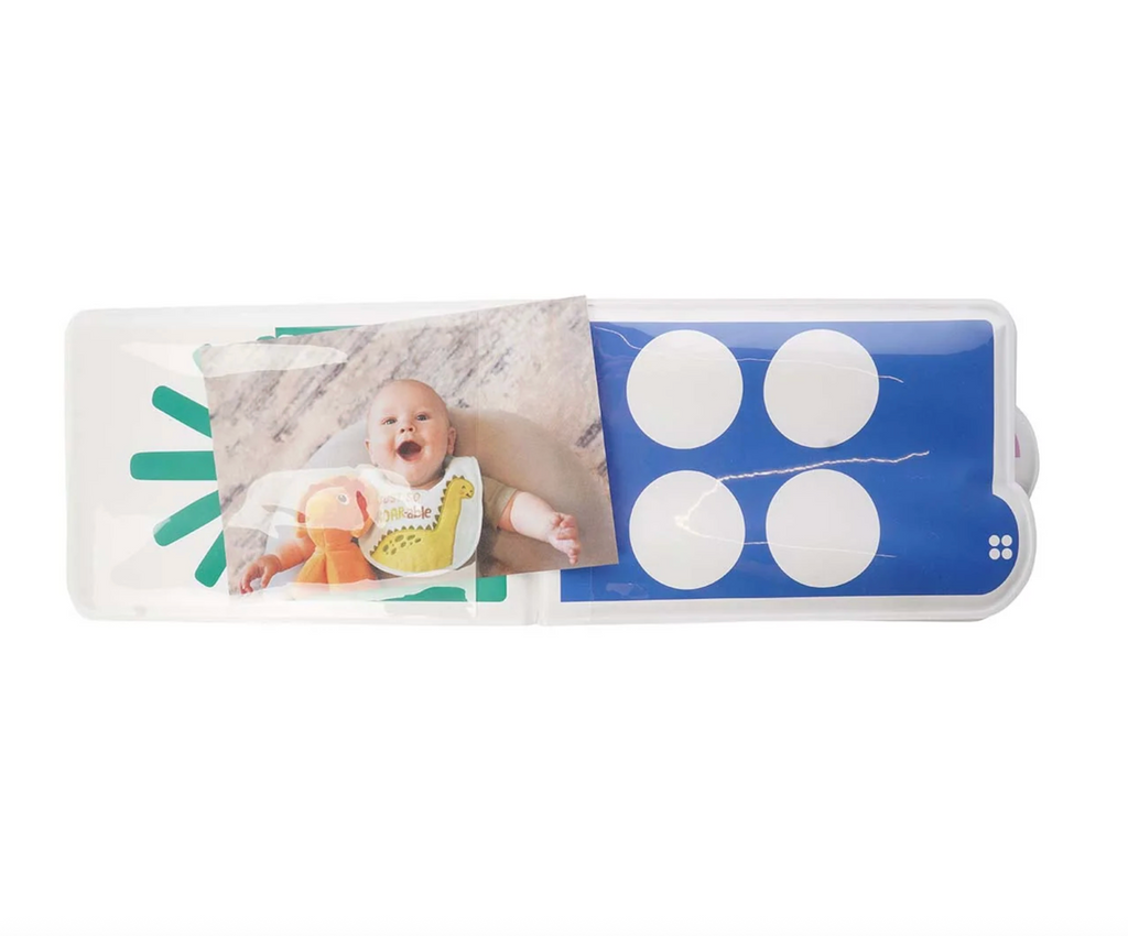 Interior pages of the My First Phototbook with a picture of a sweet baby inserted into one of the see through pages and white circles on a blue background on the opposite page. 