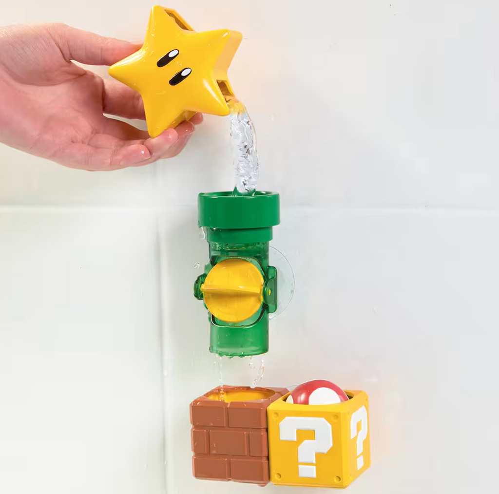 The Mario Super Star pouring water into a pipe, which is flowing into a section  waiting for the mushroom to pop up, all the pieces are attached to the wall of the bathtub with suction cups. 