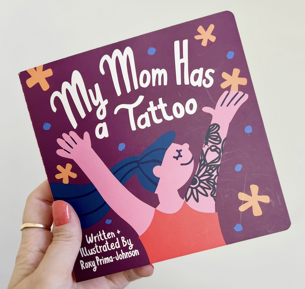 Illustrated cover of "My Mom Has a Tattoo" board book with an image of a mother with lots of tattoos on her arm. 