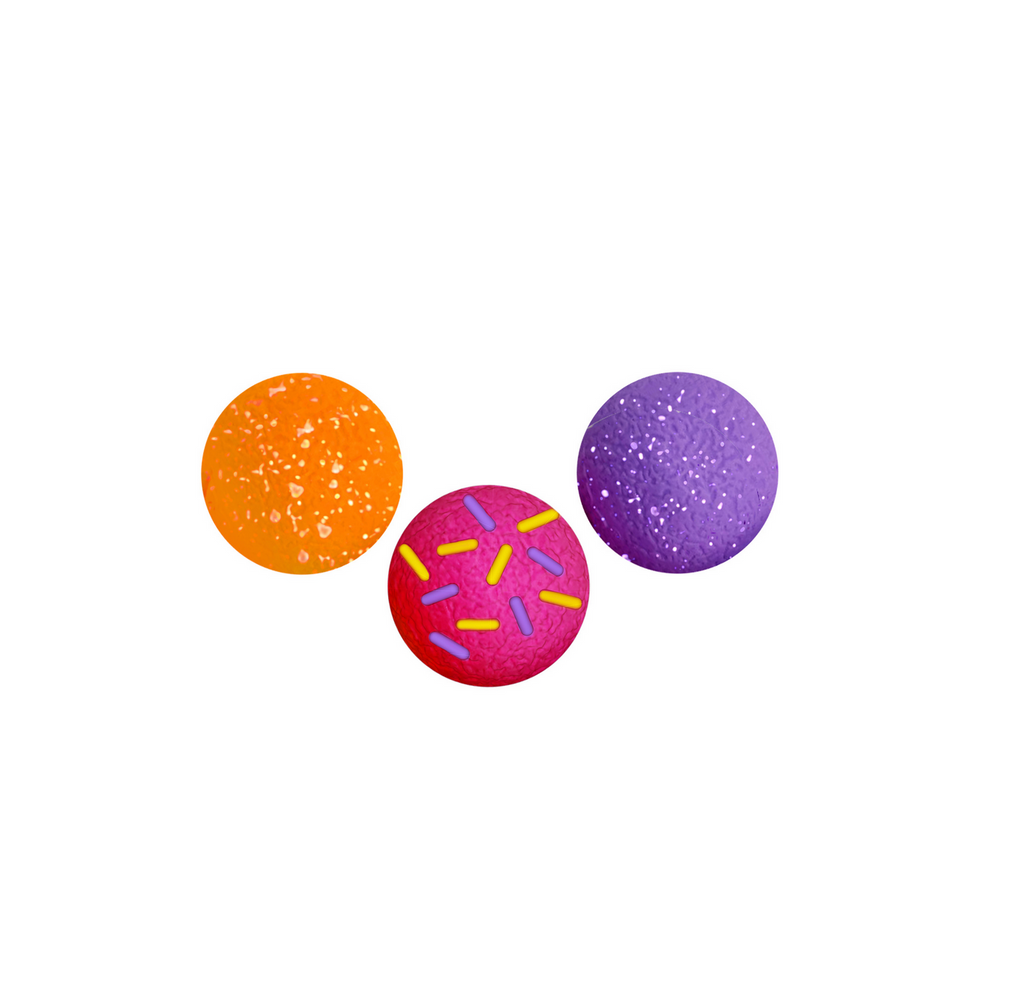 3 different NeeDoh Dohnut Holes on a white background: orange with white specks, purple with white specks, and bright pink with rainbow "sprinkles".