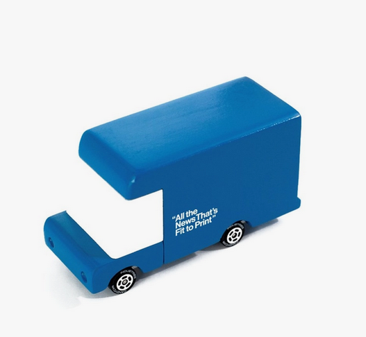 The drivers side view of the New York Times blue delivery van toy with it's iconic quote "All thr News That's Fit to Print" painted on the side. 