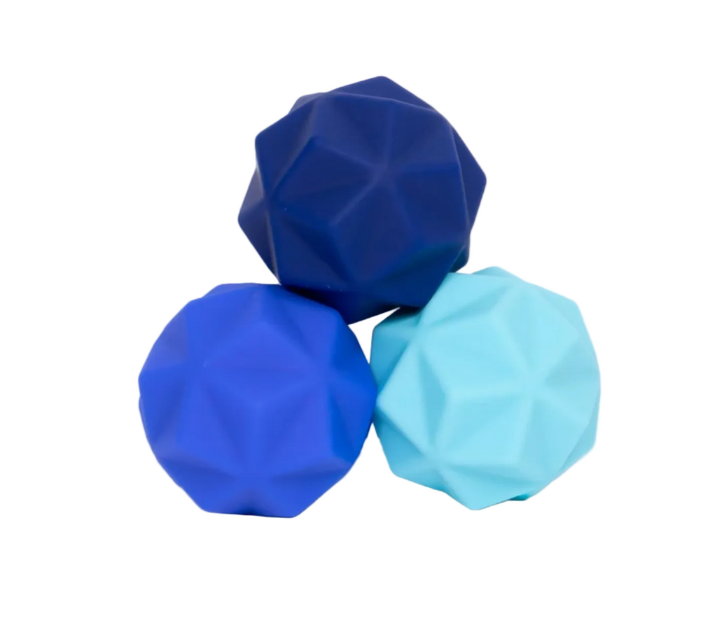 The Speks Odds Blue Peak set. Three faceted geometric stress balls in dark blue, bright blue, and light blue. 