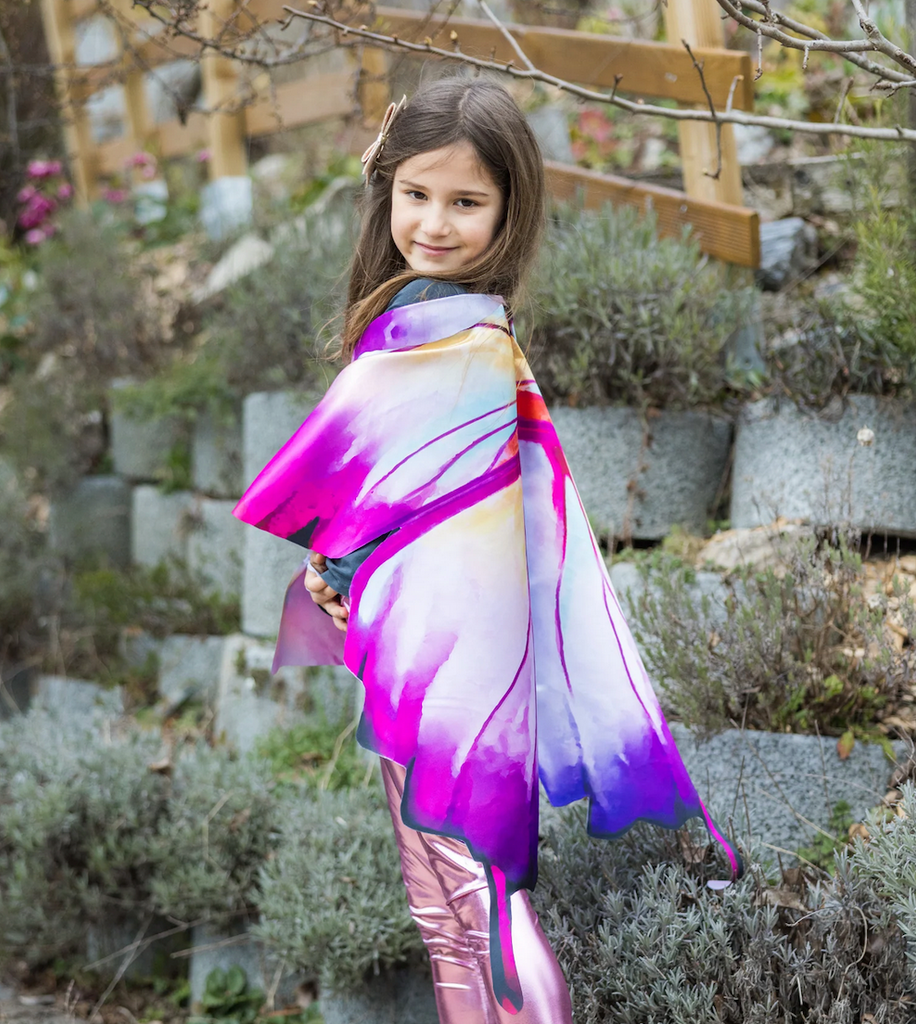 A child wearing the Ombre Butterfly Soft Wings and looking over her shoulder. 