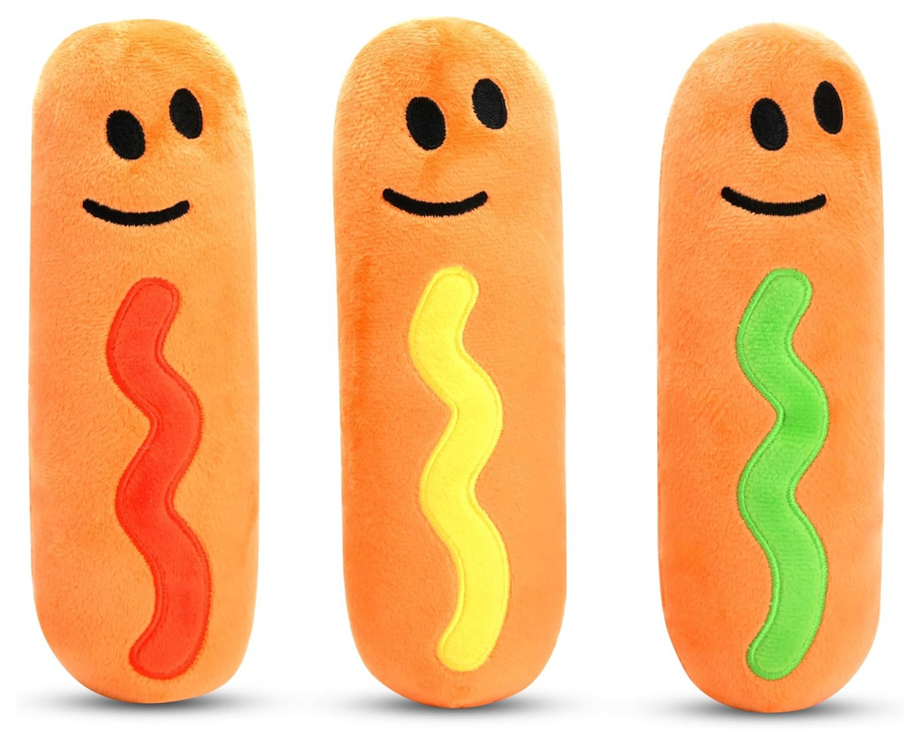 Three plush hot dogs with smiley faces and different colored condiments. 
