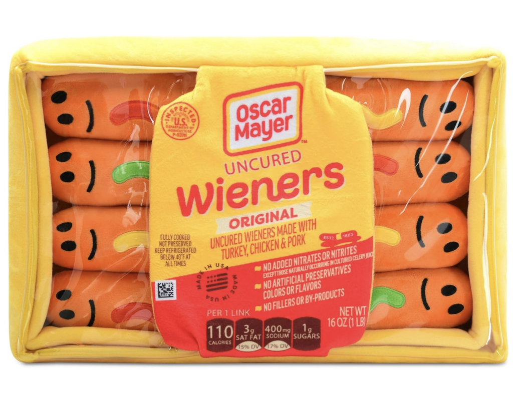 The full-color pillow is comprised of a yellow fleece zipper closure box shaped pillow with a clear window in the front to show the eight smiling plush hot dog buddies inside. 