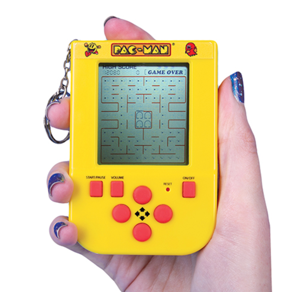 The Pac Man Arcade game being held in a hand with the keychain.