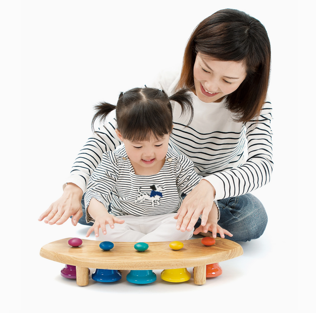 Mother and child sitting on floor playing with Pat Bells Station.