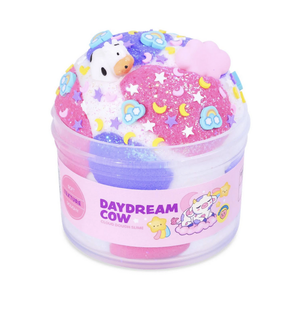 Daydream Cow cloud dough slime in a clear tub that shows the white, purple and pink slime with cow charm, colorful moon, tars and rainbow sprinkles. Not food, do not eat. 