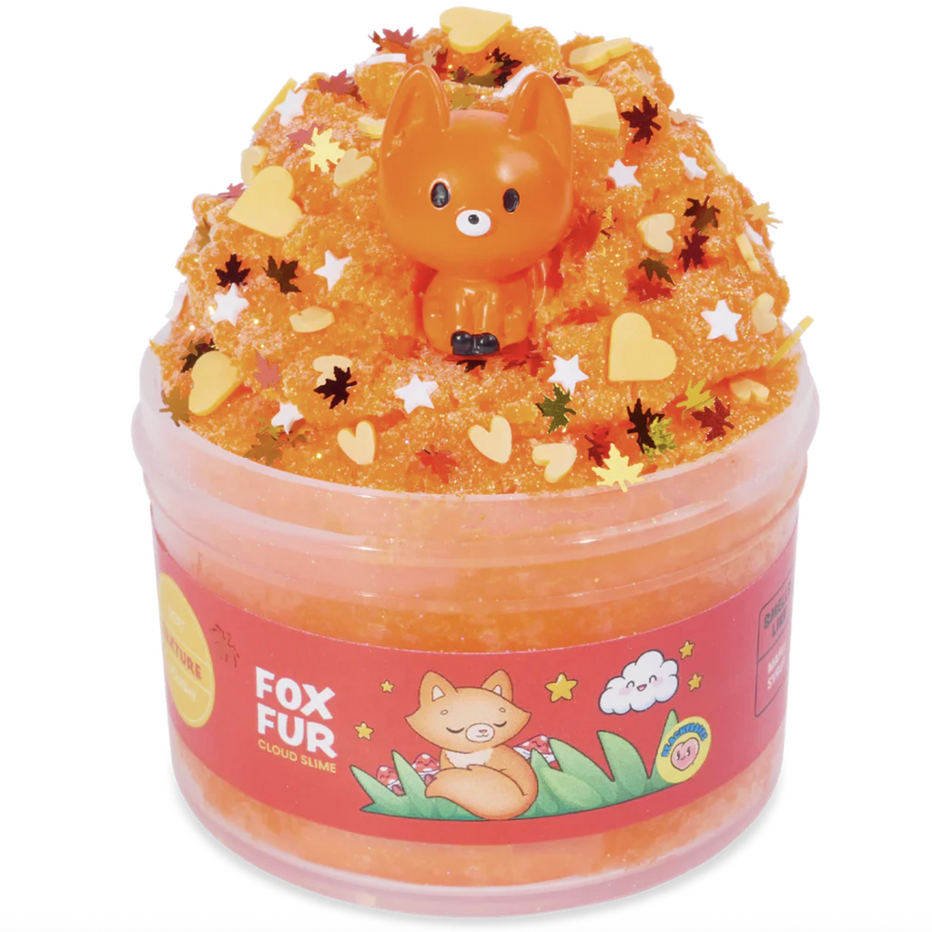 Orange cloud slime in a clear container with a fox charm and heart shaped charms with gold and orange leaf sprinkles. 