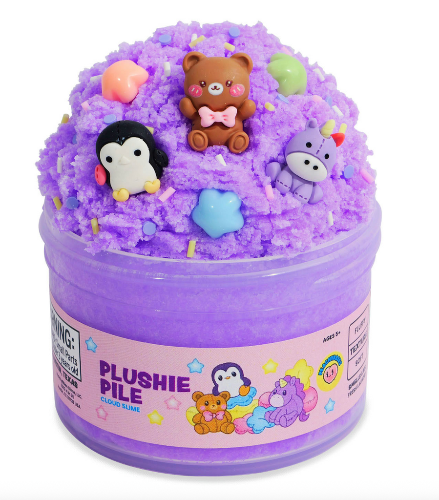 A clear container overflowing with purple cloud slime with stuffed animal charms and colorful sprinkles to mix in. 