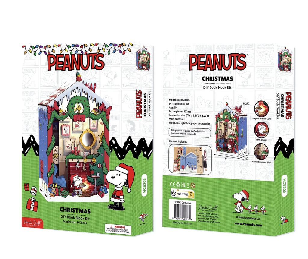 The Peanuts Christmas DIY Miniature Book Nook Kit packaged in a white ox with a picture of the kit fully built and Snoopy as Santa standing beside the book nook. 