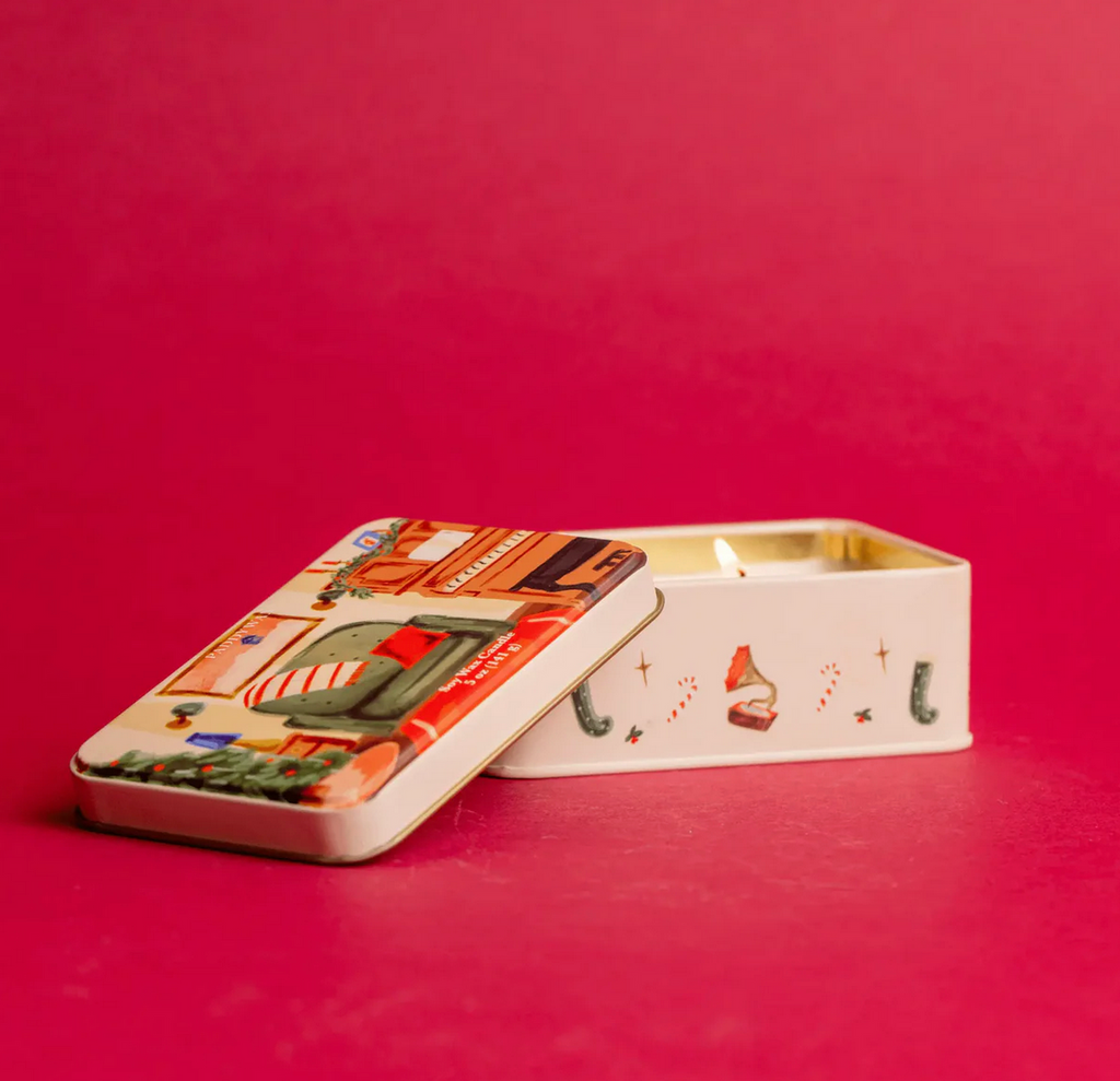 Decorative candle in a tin with a festive design on a red background