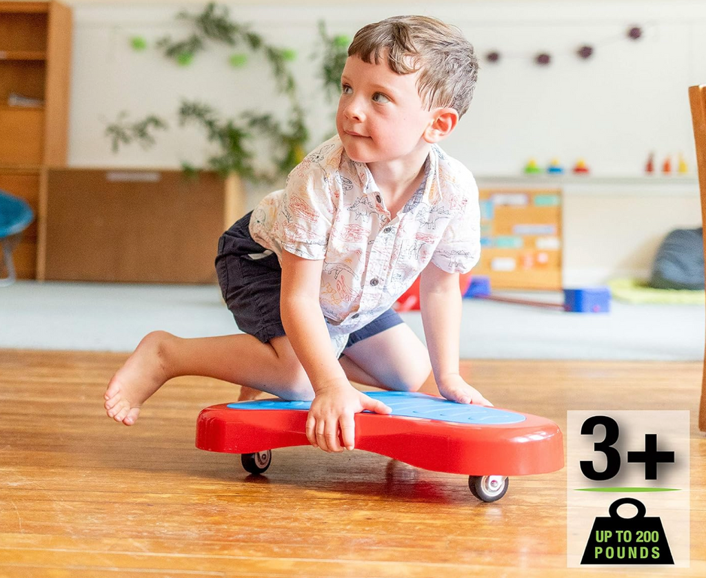 A young boy kneeling on the tri-flyer and riding it around the room. 