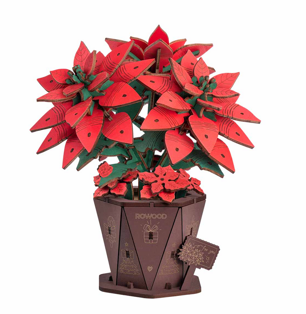 Red and green wooden Poinsettia 3D puzzle set in a brown planter which is part of the puzzle as well. 